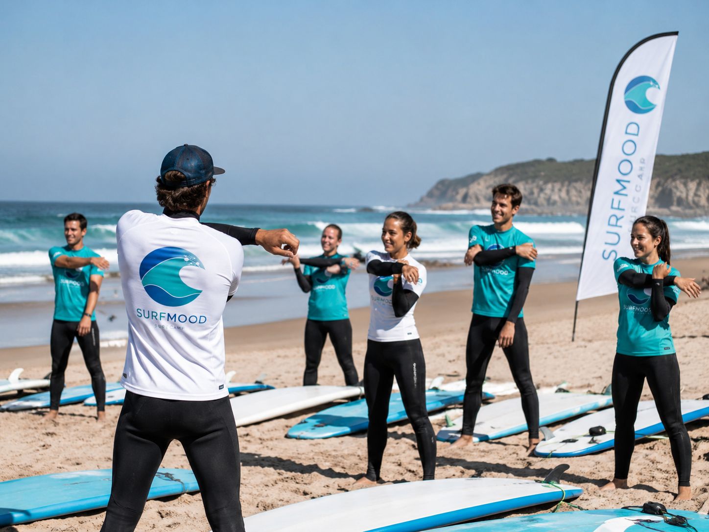 Calentamiento antes de la clase de surf Grupo de alumnos de SurfMood haciendo ejercicios de calentamiento antes de entrar al agua.