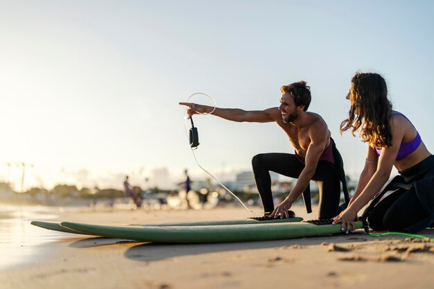 Dos surfistas en la playa revisando el equipo antes de entrar al agua