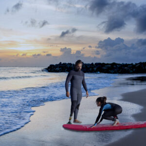 Instructor dando clases de surf a una niña